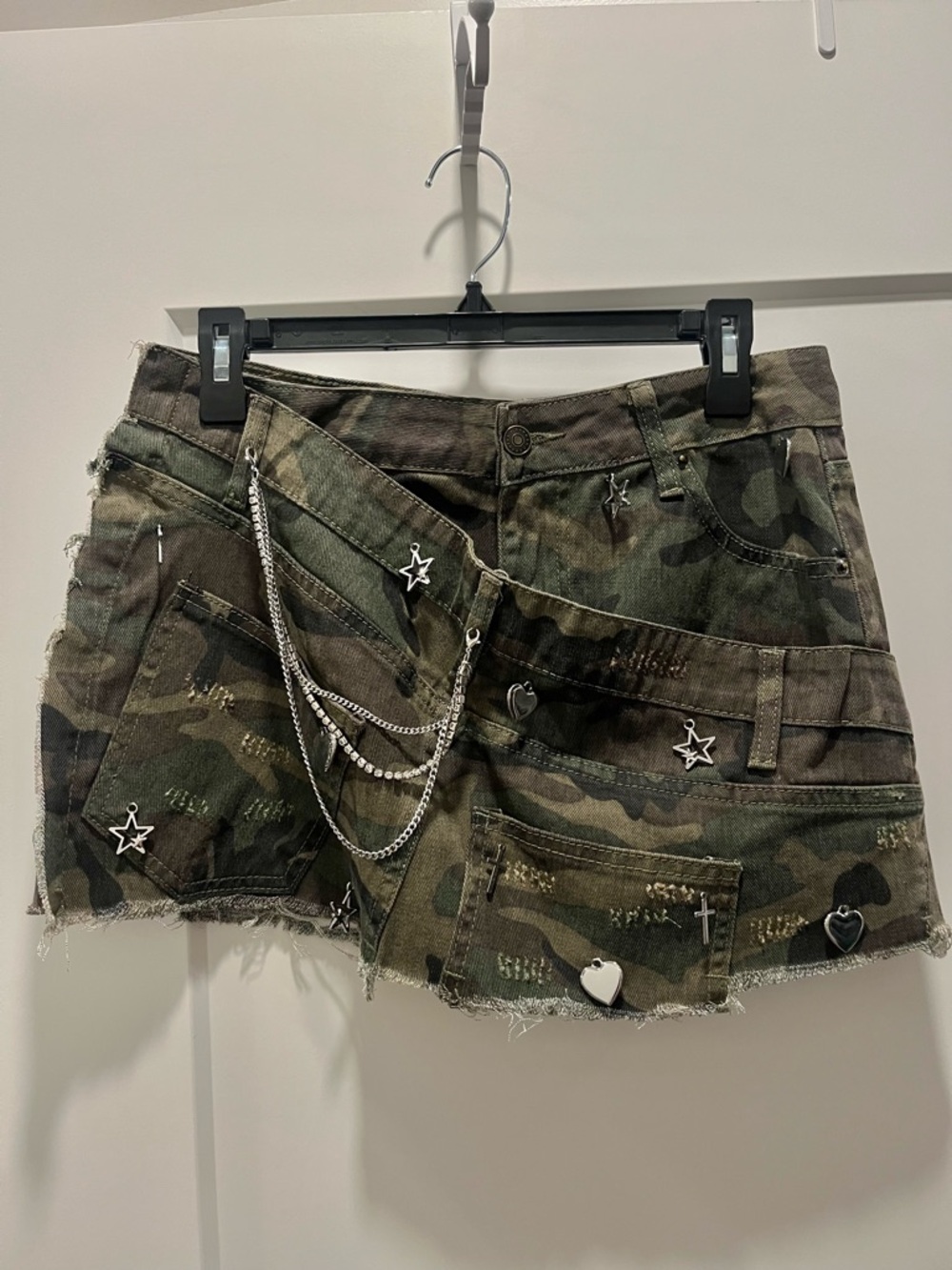 Distressed camouflage denim mini skirt with metal charm details. New with tags!